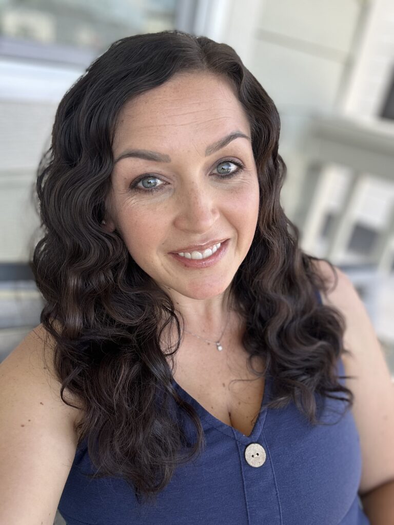 Founder, Nicole Bonaire, headshot sitting on porch blurred background